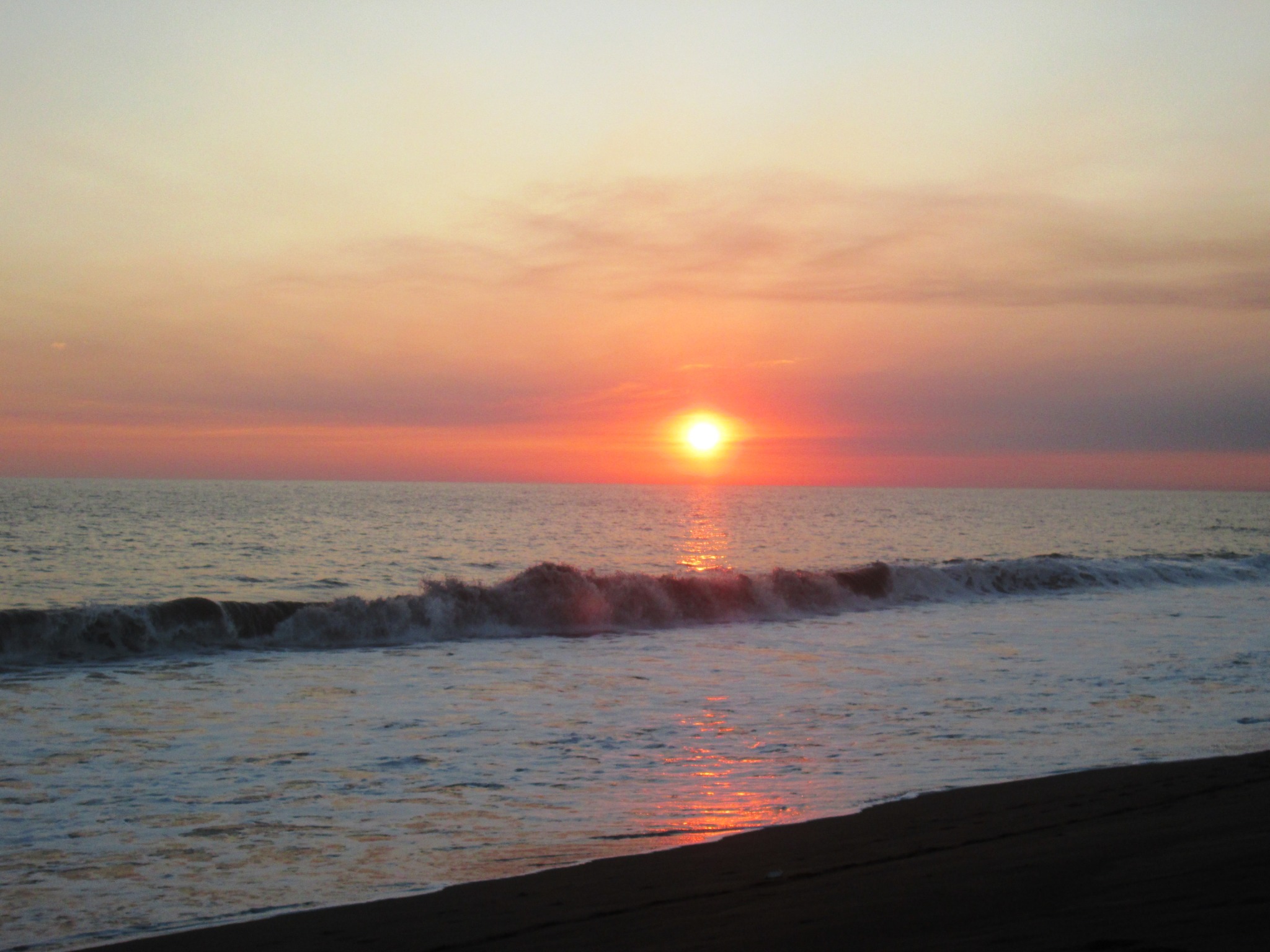 Puesta de sol sobre las olas del Pacífico en Monterrico