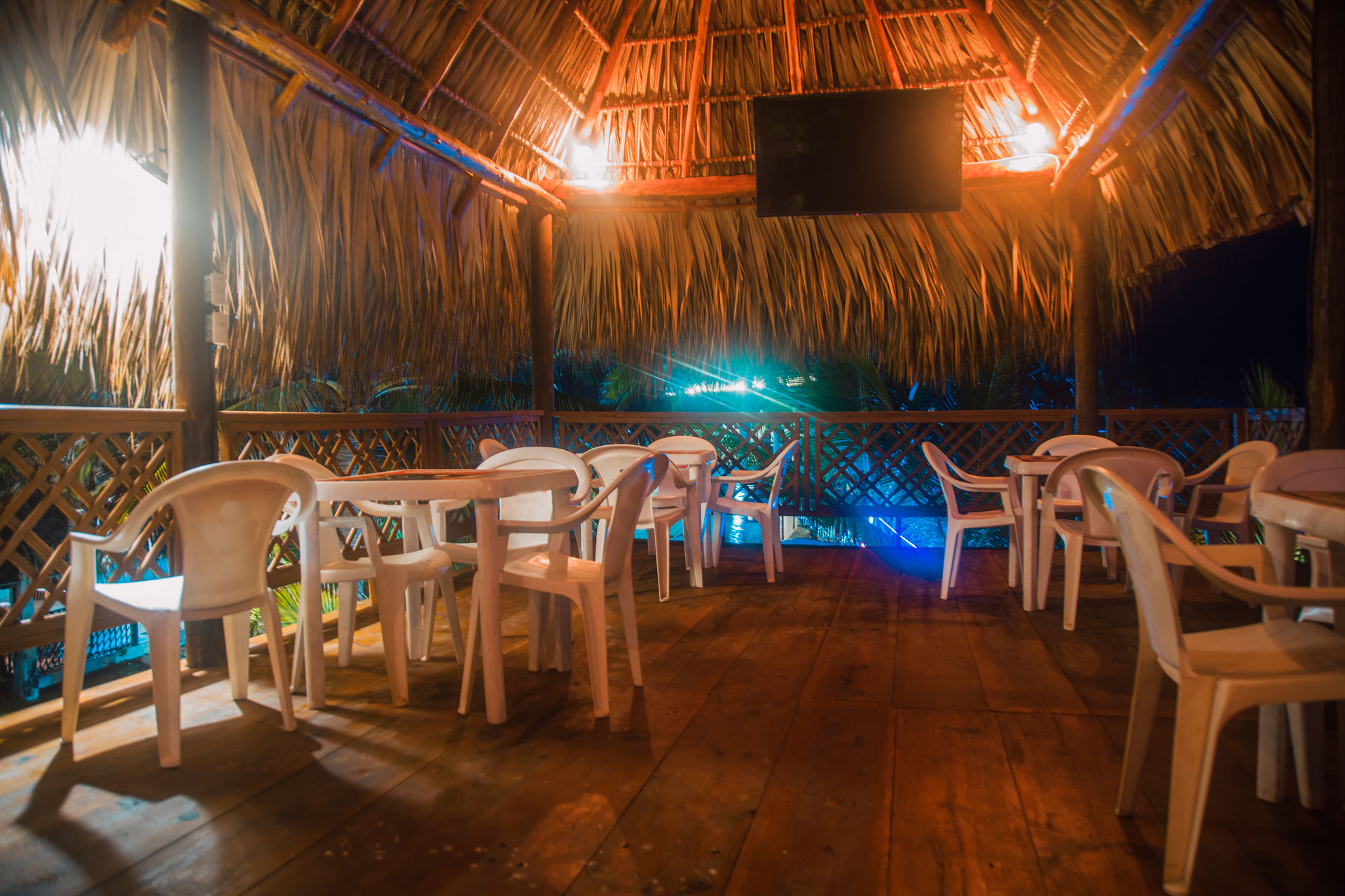 Restaurante de techo de palma iluminado por la noche