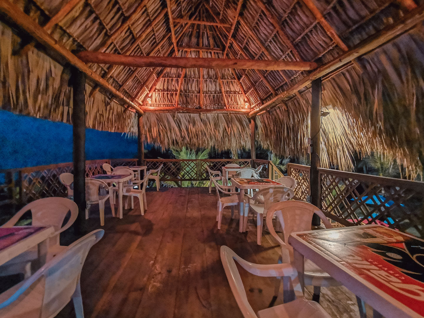 Terraza superior del pub con mesas bajo el techo de palma